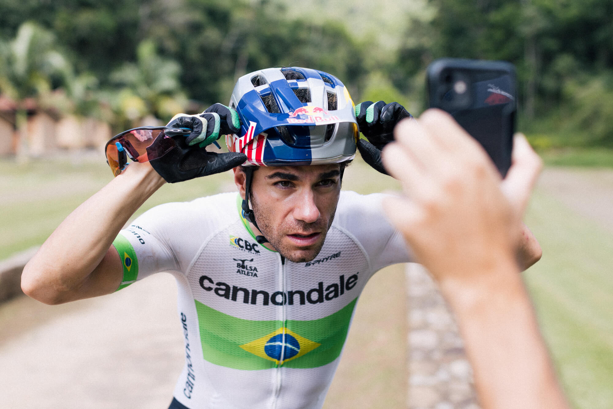 Henrique Avancini utilizando su casco Red Bull montando en bici de montaña en Brasil