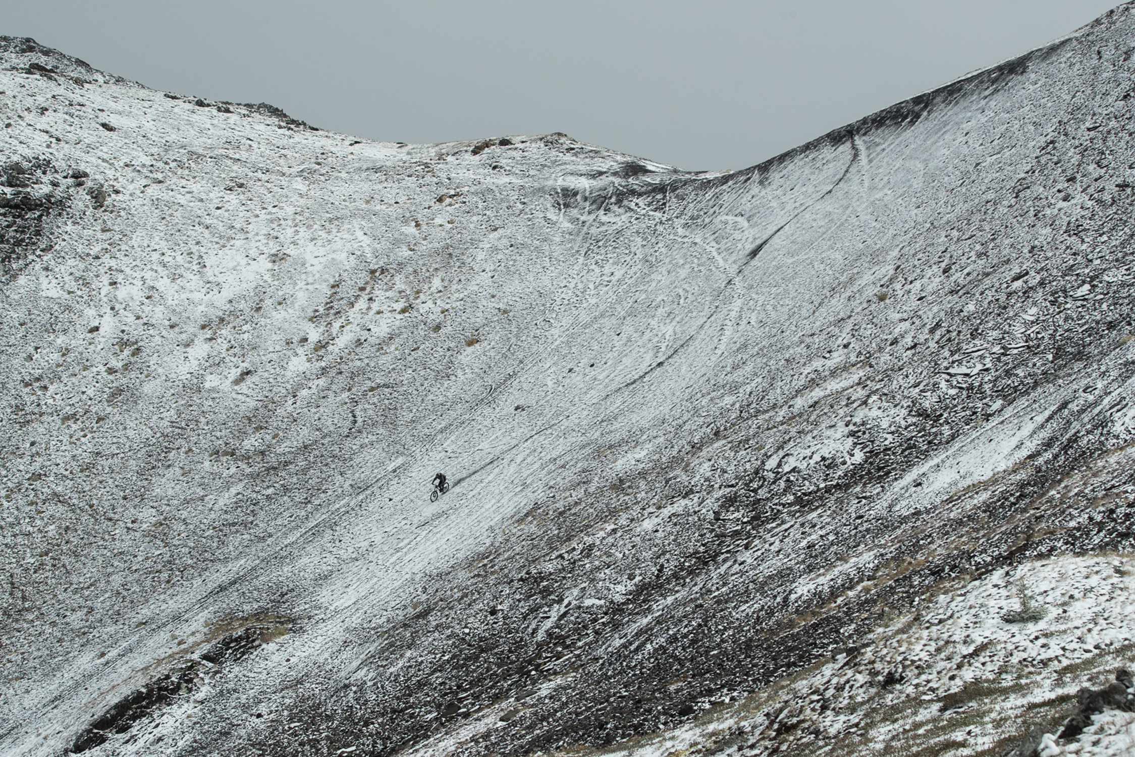 Kurt Sorge sykler ned et snødekt fjell 