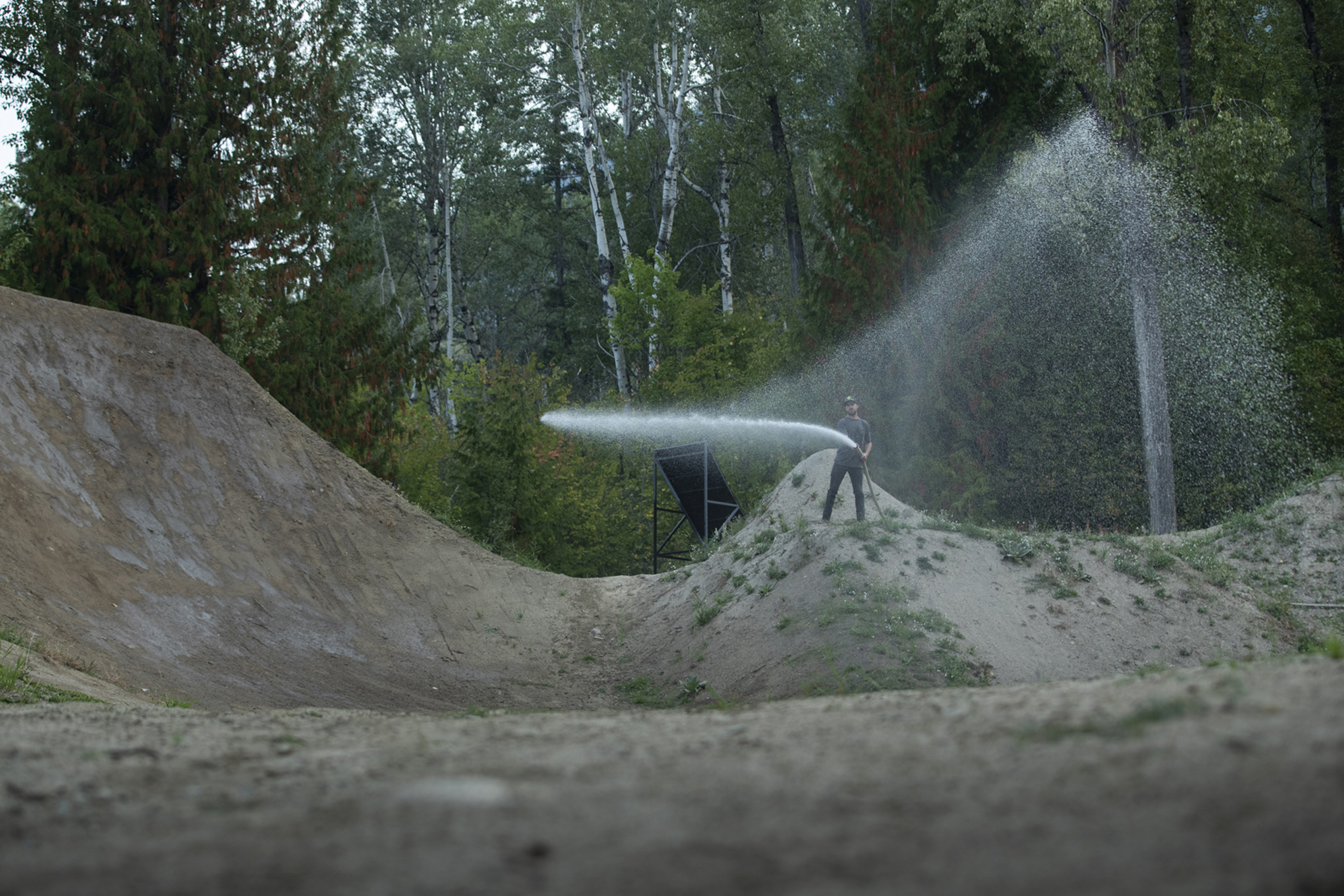 Kurt Sorge polewający wodą skocznie w swym ogrodzie