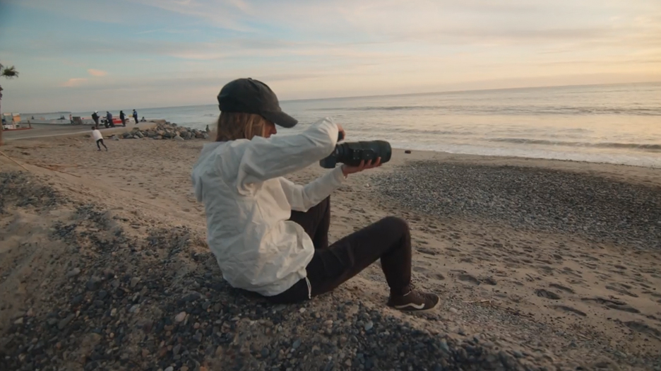 Heather Young taking a photo at the beach 