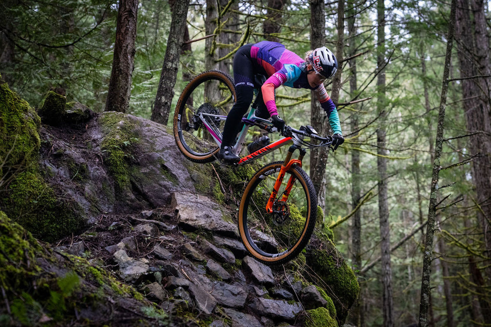 Emily Batty riding her bike down a steep rock section