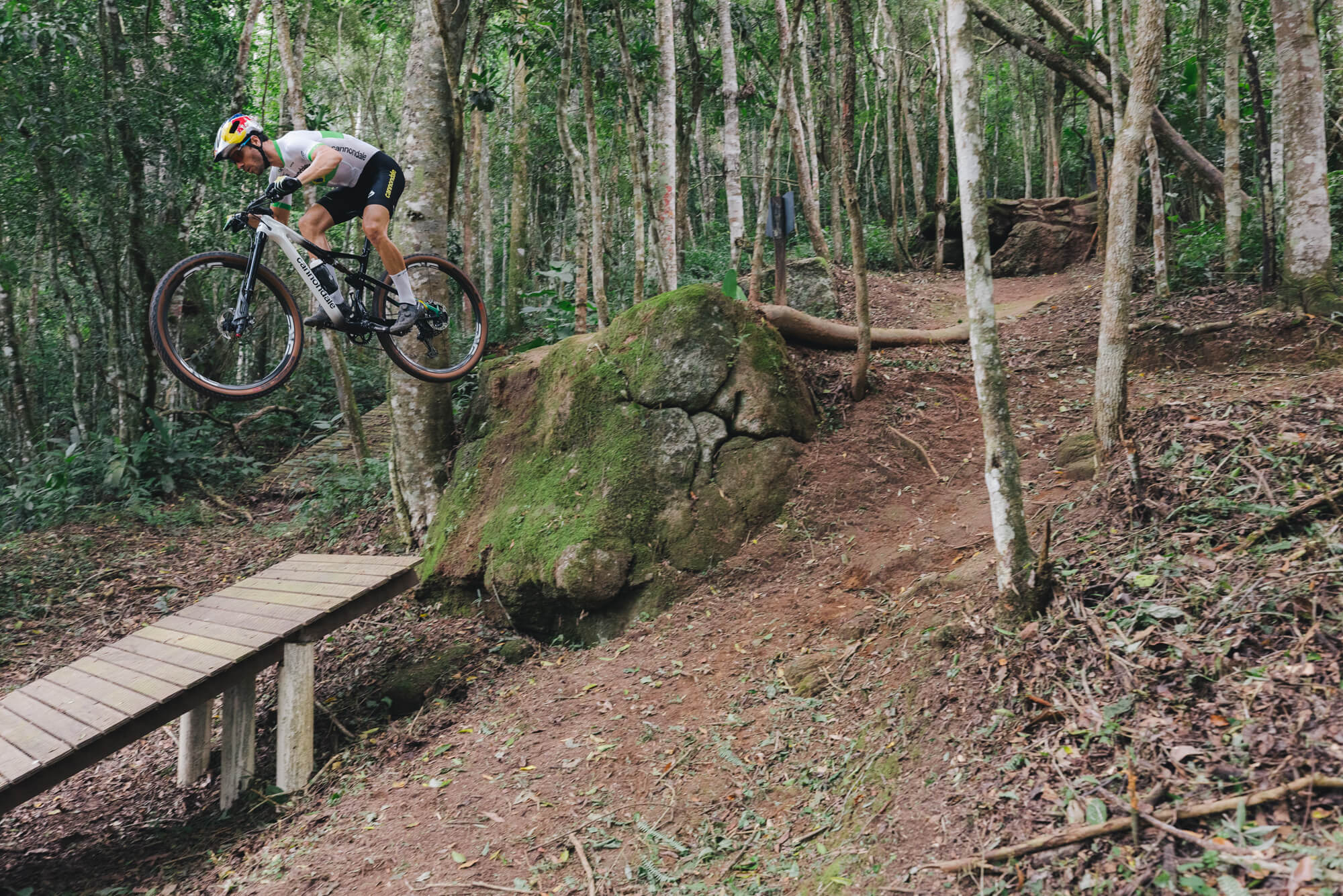 Pro mountain biker hitting a drop off on his mountain bike 